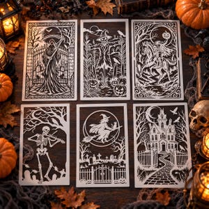 May include: A set of six rectangular white stencils featuring intricate Halloween designs including a grim reaper, a scarecrow, a headless horseman, a skeleton playing a violin, a witch on a broomstick, and a haunted mansion with a stone path.