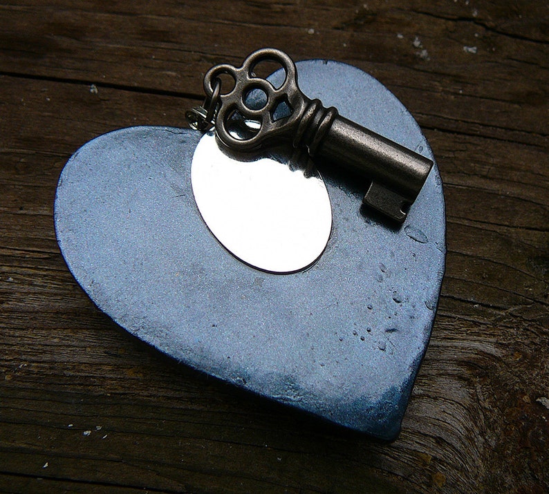 May include: A blue heart-shaped ornament with a silver mirror inside and a vintage-style key attached.