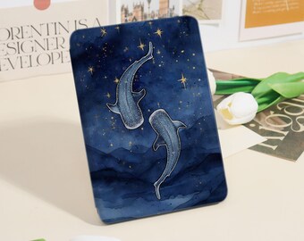 May include: A rectangular phone case featuring a watercolor design of two whale sharks swimming in a dark blue night sky with gold stars. The case has a glossy finish and a protective design.