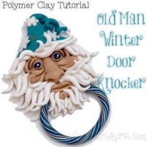 May include: A polymer clay door knocker shaped like an old man with a white beard and a blue hat. The knocker has a white ring for the door.