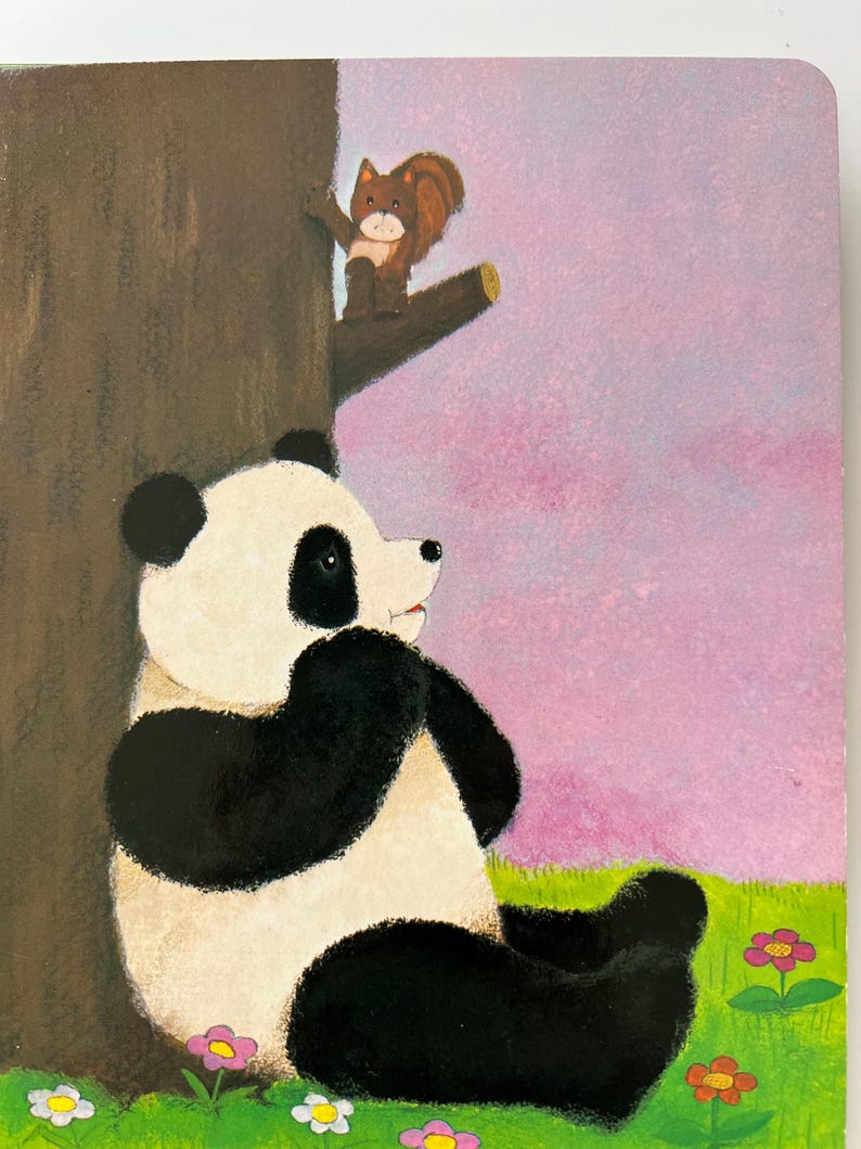 May include: A children's book illustration showing a panda bear seated on green grass with pink and yellow flowers. A brown squirrel perches on a tree branch above the panda against a purple and pink sky.