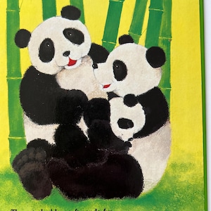 May include: A colourful illustration from a children's book showing two pandas in a bamboo forest. The pandas are black and white with red details, set against a yellow and green backdrop. Text reads, "They stroked her soft panda fur."