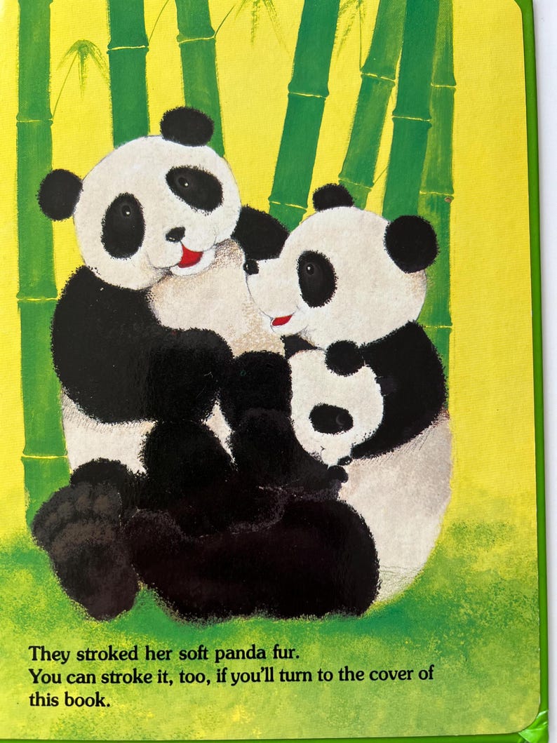 May include: A colourful illustration from a children's book showing two pandas in a bamboo forest. The pandas are black and white with red details, set against a yellow and green backdrop. Text reads, "They stroked her soft panda fur."