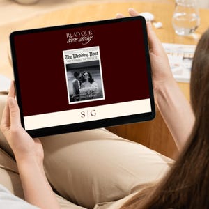 May include: A black tablet shows a digital wedding publication. The screen displays the text "Read Our Love Story" and "The Wedding Post" with a black and white photo of a couple. The initials "S G" are at the bottom.