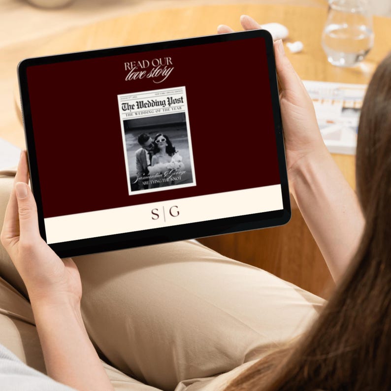 May include: A black tablet shows a digital wedding publication. The screen displays the text "Read Our Love Story" and "The Wedding Post" with a black and white photo of a couple. The initials "S G" are at the bottom.