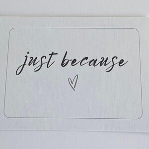 Könnte beinhalten: Eine weiße Karte mit dem Schriftzug "just because" in kursiver Schrift, begleitet von einem kleinen Herzsymbol. Das Design der Karte ist schlicht und elegant, passend für verschiedene Anlässe.