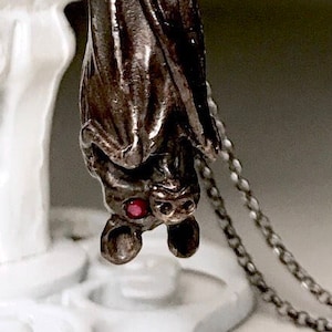 Hanging  Black Bat Necklace, ruby eyed, in Sterling Silver, made in NYC, Blue Bayer Design