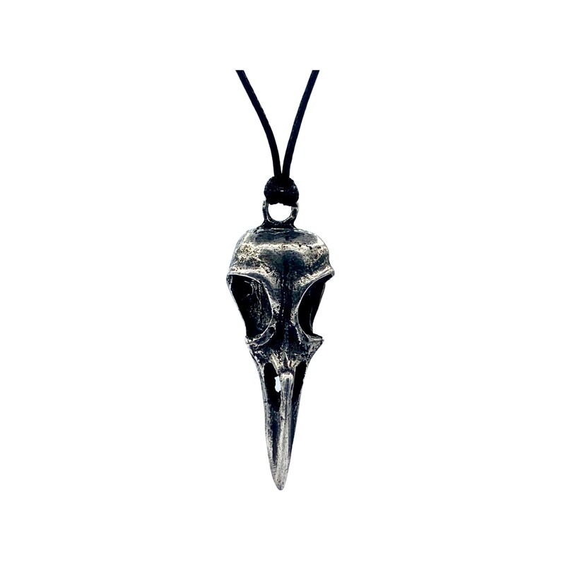 May include: A silver bird skull pendant necklace with a black cord.