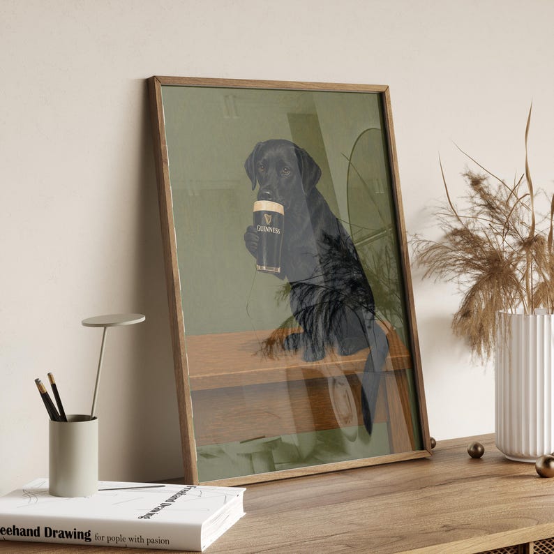 Pu&ograve; includere: Stampa artistica incorniciata raffigurante un Labrador Retriever nero che tiene in mano una pinta di Guinness. Il cane &egrave; ambientato in un pub, con un bancone di legno e uno sfondo verde. Il logo Guinness &egrave; visibile sul bicchiere.