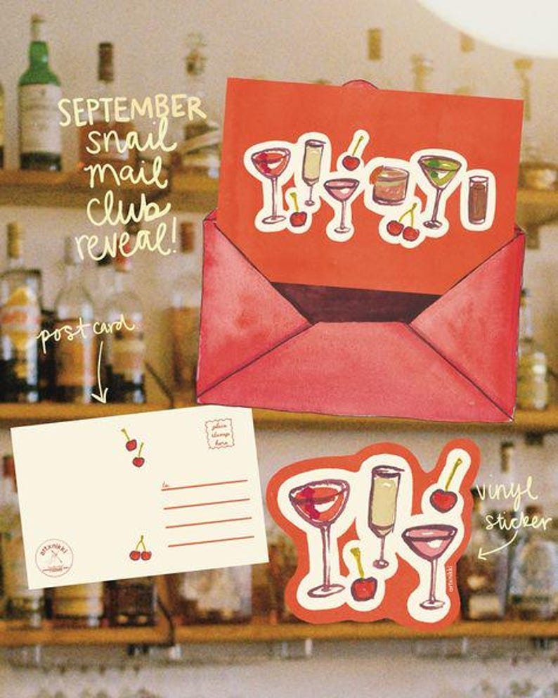 May include: A red envelope with cocktail stickers and a postcard. The stickers feature various cocktail glasses and cherries. The postcard has lines for writing and cherry illustrations. Text on the envelope reads "September snail mail club reveal!"