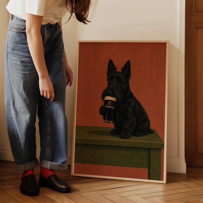 May include: A framed print featuring a black Scottish Terrier holding a pint of Guinness. The dog is depicted on a green bench against a red background. The Guinness glass is black with white text.