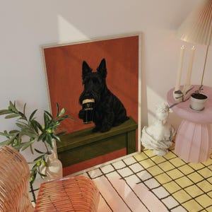 May include: A framed print featuring a black Scottish Terrier holding a Guinness pint. The dog is sitting on a green surface against a red background. The print is in a room with a lamp, candles, and a small table.