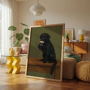 Pu&ograve; includere: Stampa incorniciata con un Labrador Retriever nero che tiene in mano una pinta di Guinness. Il cane &egrave; raffigurato seduto su una panca di legno su sfondo verde. La stampa ha una cornice in legno chiaro ed &egrave; esposta in un soggiorno.