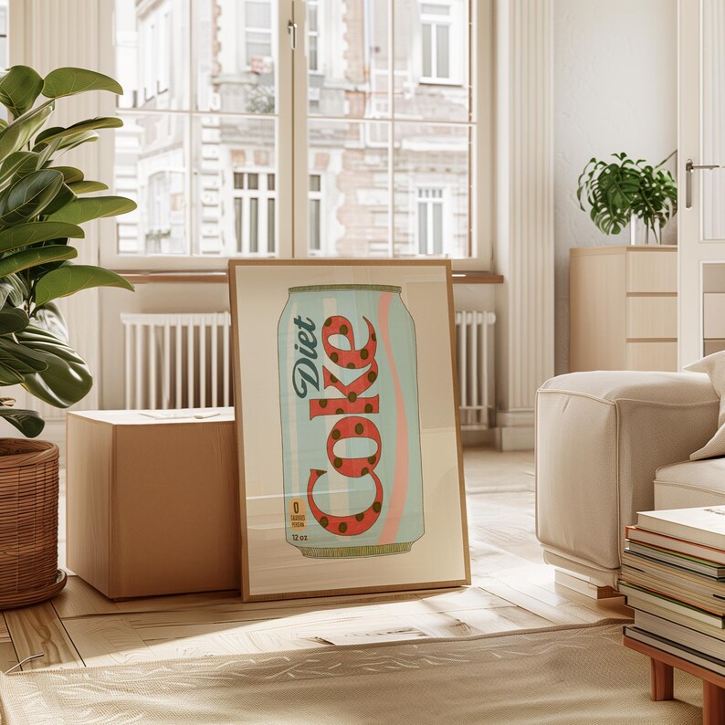 May include: A framed print featuring a Diet Coke can design. The can is light blue with a red and brown polka dot pattern spelling out "Coke". A pink wave design is on the can. The print is in a wooden frame and is displayed in a room with natural light.