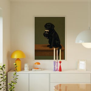 Pu&ograve; includere: Una stampa incorniciata con un Labrador Retriever nero che tiene in mano una pinta di Guinness. Il cane &egrave; seduto su una superficie di legno su uno sfondo verde scuro. La stampa &egrave; esposta sopra un mobile bianco con candele e una lampada gialla.