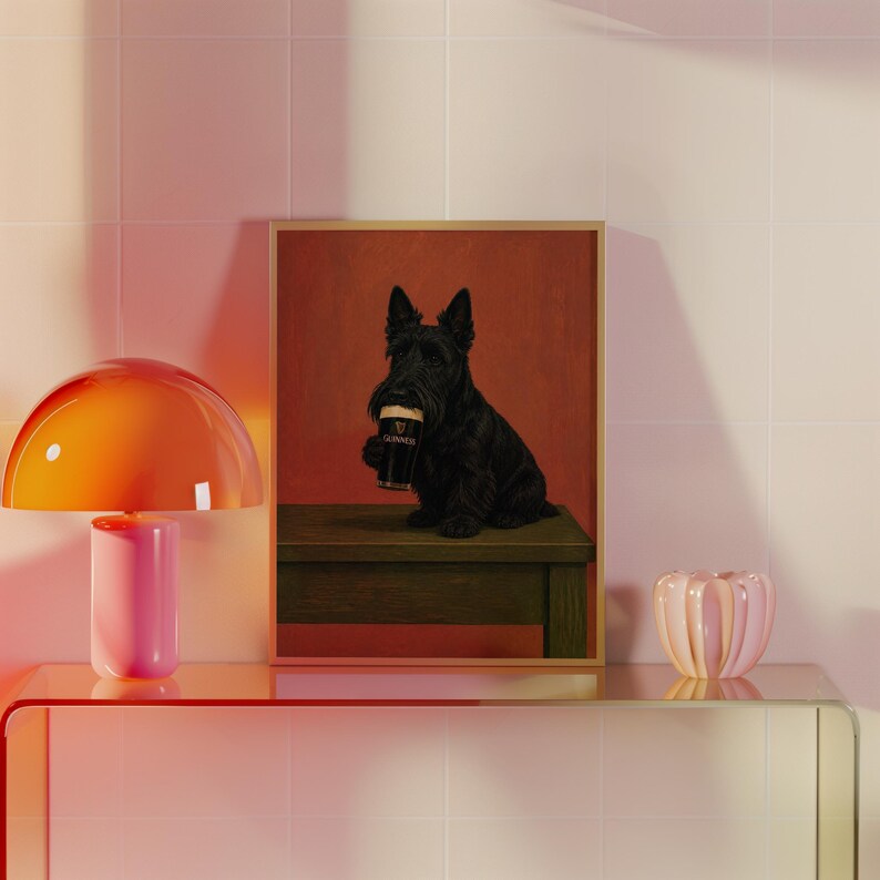 May include: A framed print featuring a black Scottish Terrier dog holding a pint of Guinness. The dog is sitting on a wooden bench against a red background. The Guinness glass is black with a white head.
