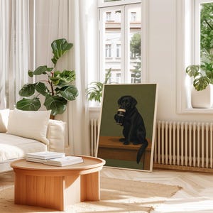Pu&ograve; includere: Una stampa artistica incorniciata con un Labrador Retriever nero che tiene in mano una pinta di Guinness. Il cane &egrave; seduto su una superficie di legno contro uno sfondo verde. La stampa &egrave; esposta in una stanza luminosa con un tavolino di legno e una grande pianta in vaso.