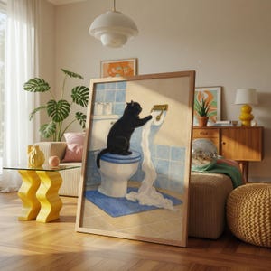 Peut inclure: Une &oelig;uvre encadr&eacute;e repr&eacute;sente un chat noir sur des toilettes, d&eacute;roulant du papier toilette. La sc&egrave;ne se d&eacute;roule dans une salle de bain avec des carreaux bleus et un tapis bleu. L'&oelig;uvre est encadr&eacute;e en bois, ajoutant une touche chaleureuse &agrave; la sc&egrave;ne.