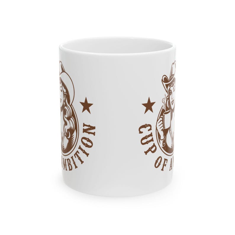 Puede incluir: Una taza de cer&aacute;mica blanca con un estampado gr&aacute;fico marr&oacute;n de una persona con sombrero de vaquero sosteniendo una taza de caf&eacute;. El dise&ntilde;o incluye una estrella y el texto "CUP OF AMBITION" en una disposici&oacute;n circular en el lateral.