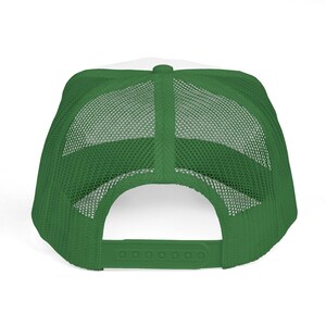 Puede incluir: Gorra de camionero verde y blanca, vista desde atr&aacute;s. La gorra presenta un panel frontal blanco y una parte trasera de malla verde. El cierre de broche ajustable es verde.
