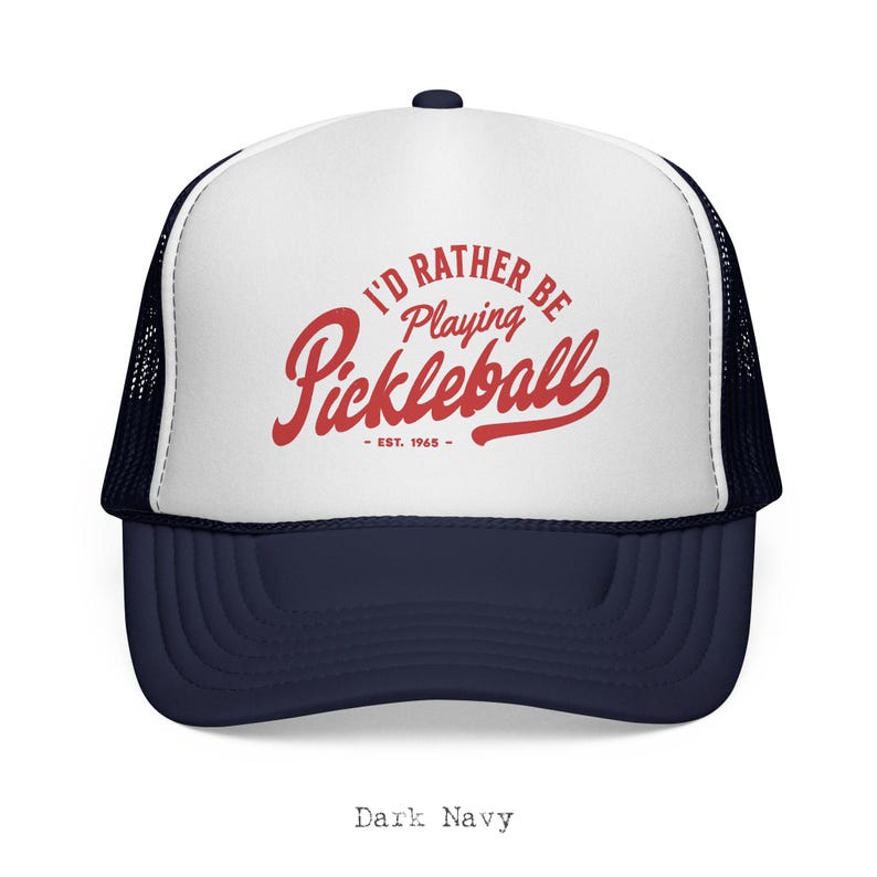 Puede incluir: Gorra de camionero azul marino y blanca con el texto "I'D RATHER BE Playing Pickleball - EST. 1965" en rojo. La gorra tiene una parte trasera de malla y una visera curva. Un accesorio casual para los entusiastas del pickleball.