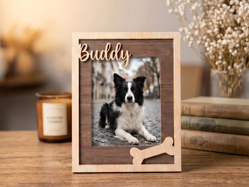 May include: A rectangular wooden picture frame featuring a light wood outer border and a dark wood inner panel. The name Buddy is cut out in light wood at the top, and a light wood bone-shaped cutout is attached at the bottom right corner.