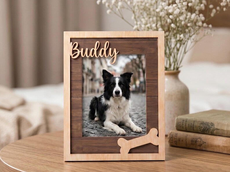 May include: A rectangular wooden picture frame with a light-colored outer border and a dark wood inner panel. The frame features the word Buddy in script lettering at the top and a bone-shaped cutout at the bottom right corner.