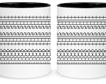 Puede incluir: Dos tazas de café blancas con asas y bordes negros. Cada taza presenta una serie de patrones geométricos negros, incluyendo líneas, zigzags, triángulos y semicírculos. Las tazas están diseñadas para bebidas calientes.