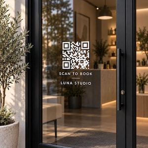 Peut inclure: Un autocollant QR code blanc appliqué sur une porte vitrée à cadre noir. Le texte sous le code indique SCAN TO BOOK et LUNA STUDIO. L'autocollant est positionné sur la surface en verre transparent, offrant une vue sur l'espace intérieur.