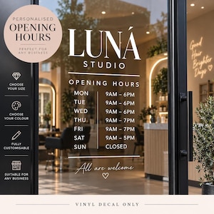 Op de afbeelding: Een witte vinylsticker aangebracht op een glazen deur met de tekst LUNÁ STUDIO, OPENING HOURS en een weekschema van maandag tot zondag. Het ontwerp bevat de zin All are welcome met een hartpictogram op een transparant oppervlak.