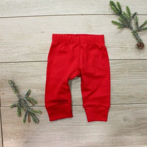 May include: Red baby leggings with a cuffed hem.