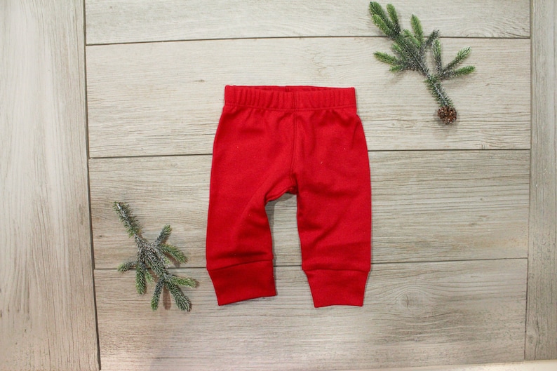 May include: Red baby leggings with a cuffed hem.