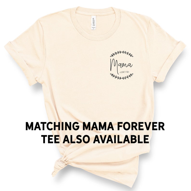 Pode incluir: Uma camiseta bege com o texto "Mama -Forever- " dentro de uma coroa de folhas.