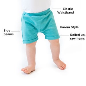 May include: Teal blue baby shorts with an elastic waistband, harem style, and rolled up raw hems.