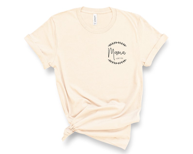 May include: A beige t-shirt with a black graphic that says "Mama Forever" inside a wreath of leaves.