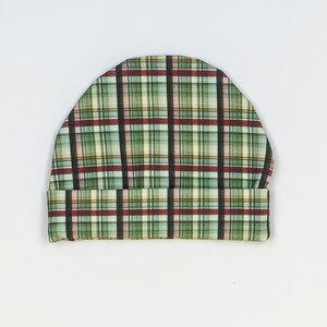 May include: A green, red, and white plaid fabric beanie hat.