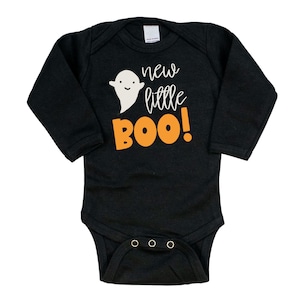 Pu&ograve; includere: Body da neonato a maniche lunghe nero con un fantasma bianco e testo arancione che dice "new little BOO!"
