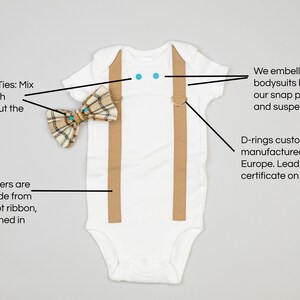 May include: A white bodysuit with tan suspenders and a plaid bow tie. The suspenders have D-rings and the bow tie has turquoise blue accents. The text "Snap on Ties: Mix and Match throughout the shop." is visible in the image.