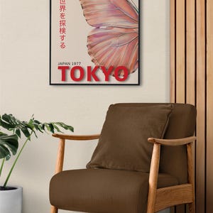 May include: A vintage poster with a butterfly illustration and the text "昆虫の世界を探検する" (Explore the world of insects) in Japanese. The poster also includes the text "風に舞い上がり" (Soaring on the wind) and "空色の翼で自由に飛ぶ命よ" (Life flies freely on azure wings). The poster is framed in black and has the text "JAPAN 1977 TOKYO" at the bottom.