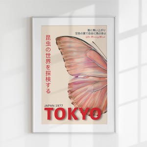 May include: A vintage poster with a butterfly wing design in shades of pink and white. The poster has Japanese text that reads "昆虫の世界を探検する" and "JAPAN 1977 TOKYO".
