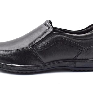 May include: Black leather slip-on shoes with a rubber sole.