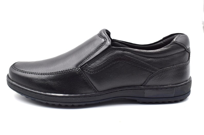 May include: Black leather slip-on shoes with a rubber sole.