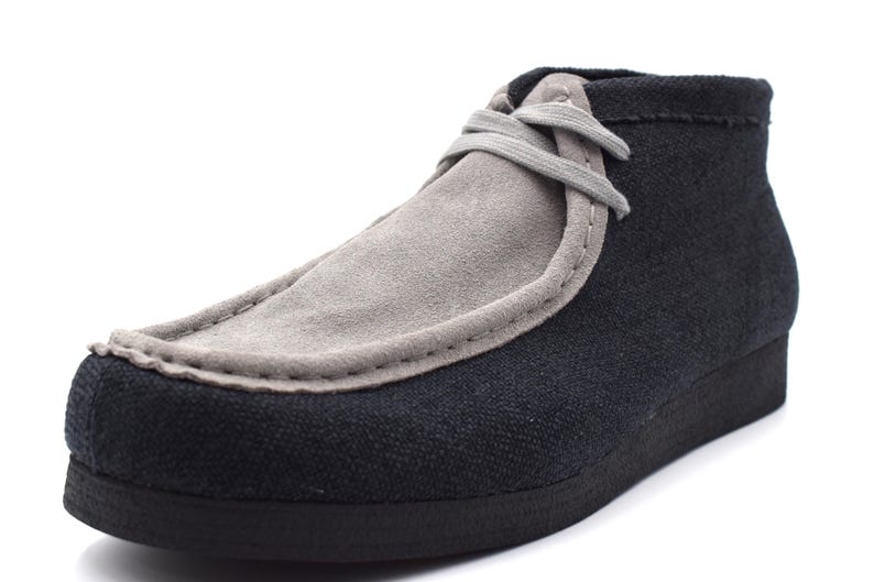 May include: A pair of black and gray suede casual shoes with a lace-up closure.