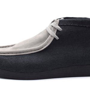 May include: A pair of black and gray canvas ankle boots with a lace-up closure.