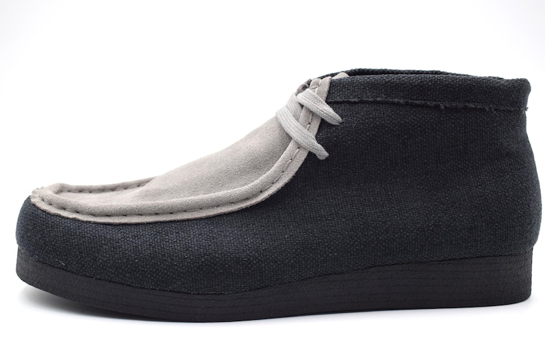 May include: A pair of black and gray canvas ankle boots with a lace-up closure.