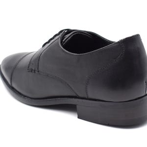 May include: Black leather lace-up dress shoe with a closed toe and a rounded heel.