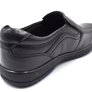 May include: Black leather slip-on shoe with a textured sole. The shoe has a simple design and is made of high-quality leather.