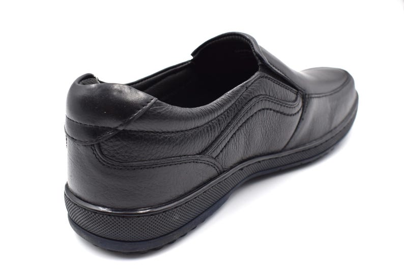 May include: Black leather slip-on shoe with a textured sole. The shoe has a simple design and is made of high-quality leather.