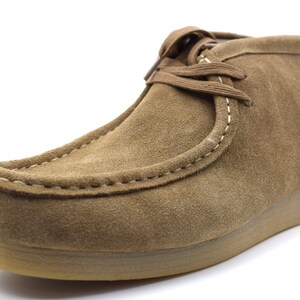 May include: A pair of brown suede ankle boots with a lace-up closure and a stitched seam around the toe.