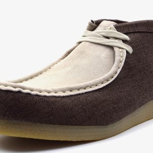 May include: Brown canvas and suede ankle boots with a lace-up closure.